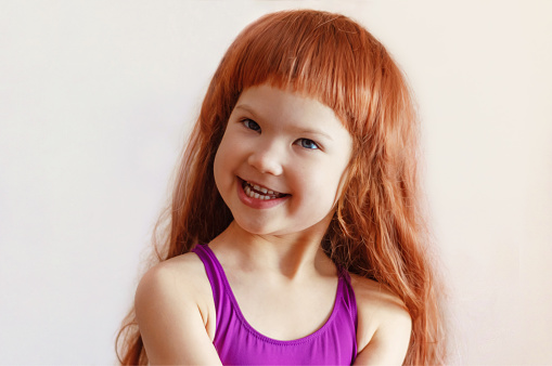 Portrait of a cheerful red-haired girl on a white background