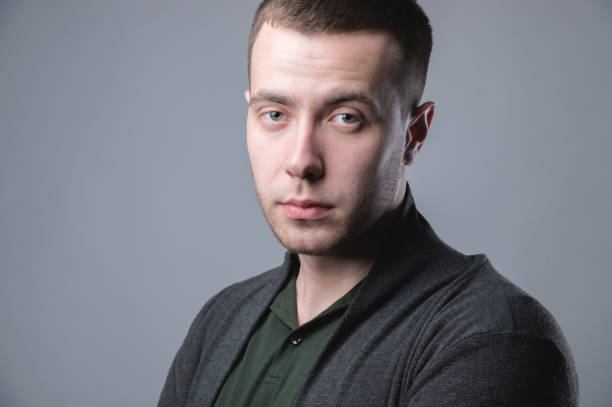 istock Attractive young man in a pullover positive relaxed view of the portrait studio on a gray background 1272743501
