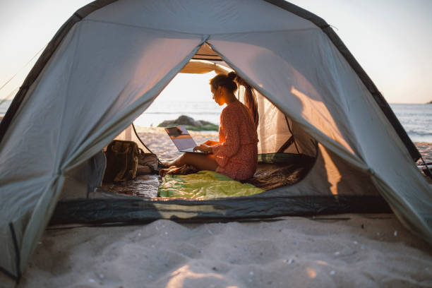 woman working with laptop on the beach. - on beach laptop working imagens e fotografias de stock