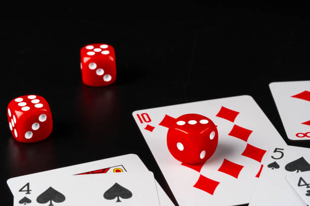 istock Dice and cards scattered on table close up 1272744566