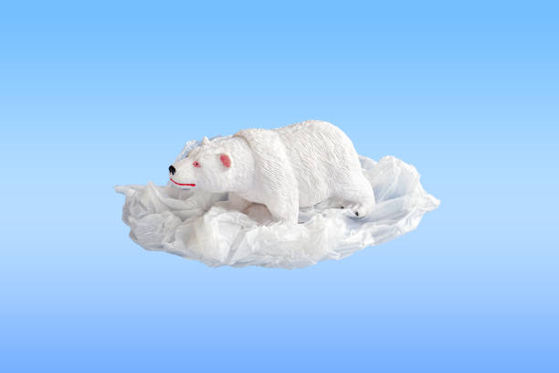 istock Polar bear toy entangled in a plastic bag on a blue background. Concept of plastic pollution. Environmental Problem. Copy space for text 1272745452
