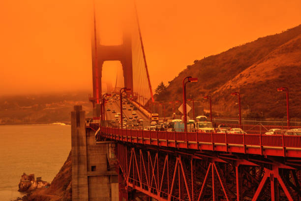 Golden Gate bridge californian fires Cars crossing Golden Gate Bridge from Lime point. Smoky orange sky the bridge of San Francisco city for California fires in America. Wildfires composition. forest fire photos stock pictures, royalty-free photos & images