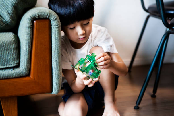 istock Boy is touching a robot toy 1272749536