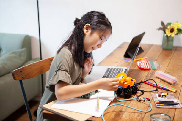 istock Girl making an electronic robot at home 1272749679
