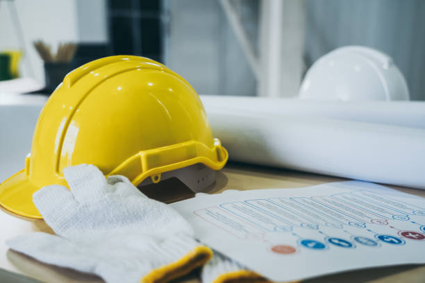 Safety helmet and glove on table at project site stock photo