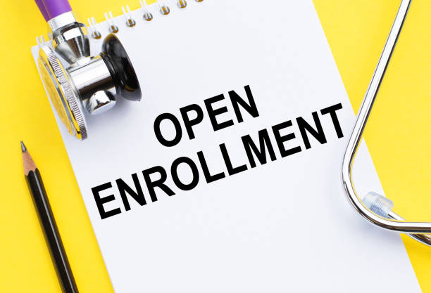 istock Doctor's yellow desk with notebook and text - Open Enrollment 1272751391