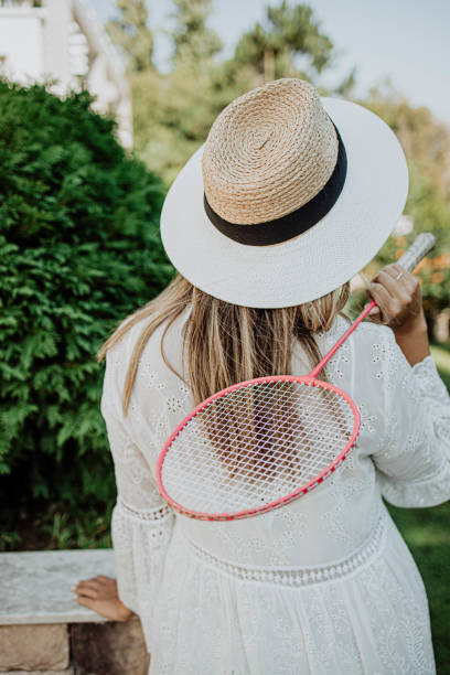 istock Young woman with badminton racket 1272757433