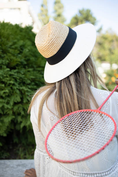 istock Young woman with badminton racket 1272757435