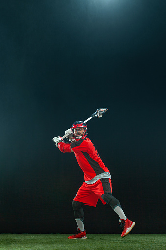 Lacrosse player running and scooping up the ball during a game