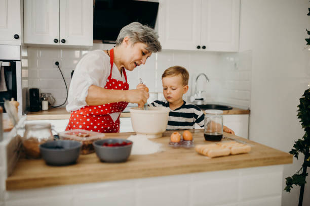 istock Grandma and grandchild bake cake 1272760381