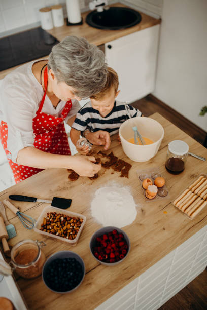 istock Grandma and grandchild bake cake 1272760591
