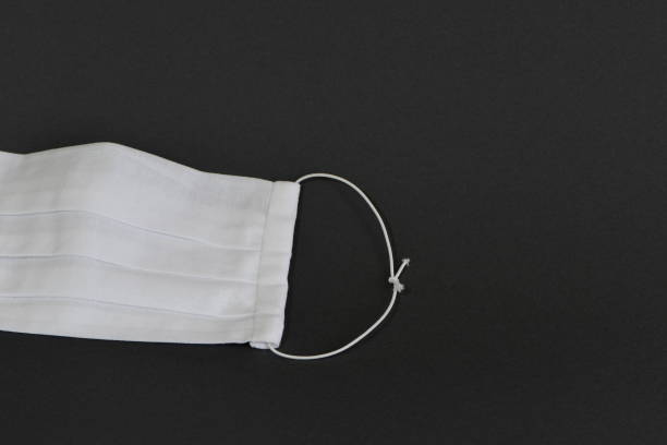 Handmade medical face mask on black background.