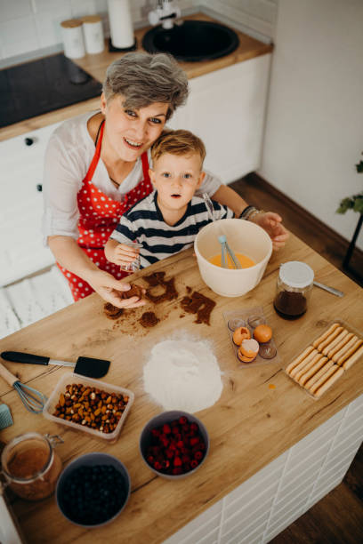 istock Grandma and grandchild bake cake 1272760636