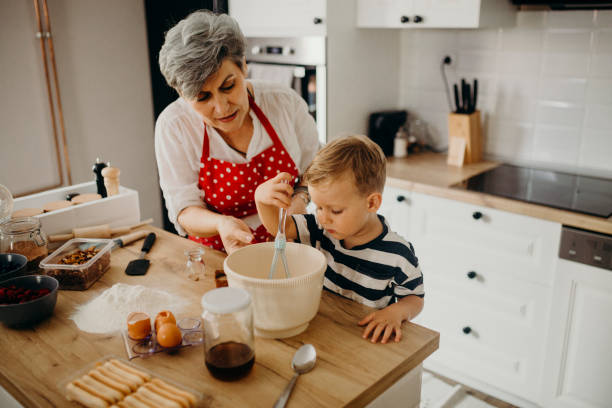 istock Grandma and grandchild bake cake 1272760665