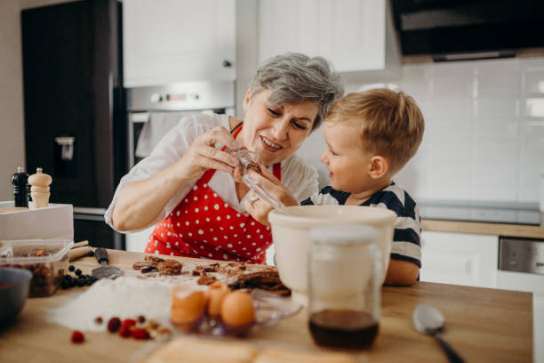 istock Grandma and grandchild bake cake 1272760681