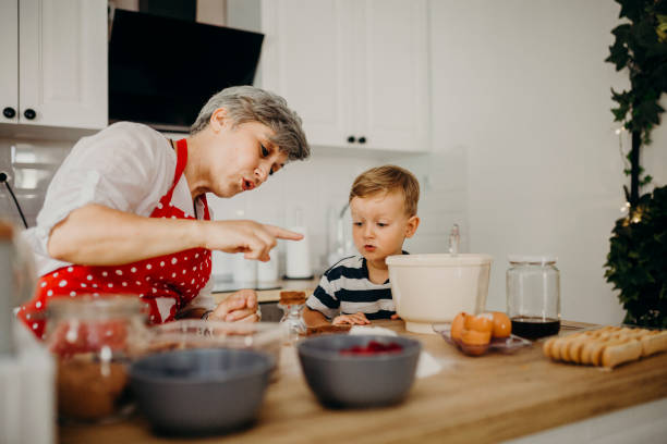 istock Grandma and grandchild bake cake 1272760787