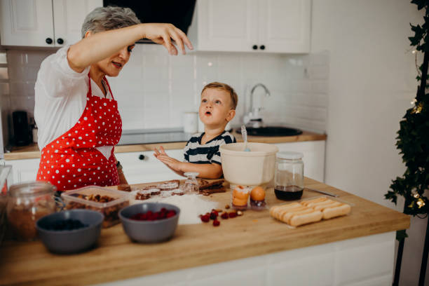 istock Grandma and grandchild bake cake 1272760842