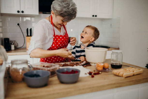 istock Grandma and grandchild bake cake 1272760872