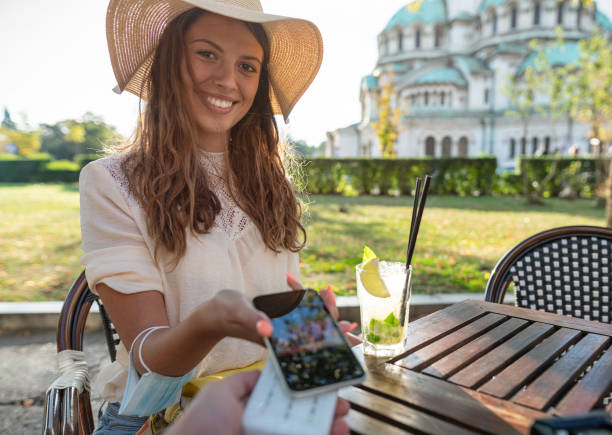 istock Young woman paying with her phone 1272760974