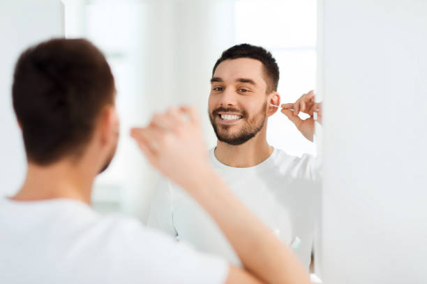 istock man cleaning ear with cotton swab at bathroom 1272761152