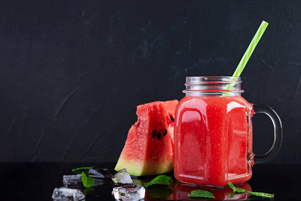 istock Fresh delicious watermelon smoothie with ice on dark background 1272761195