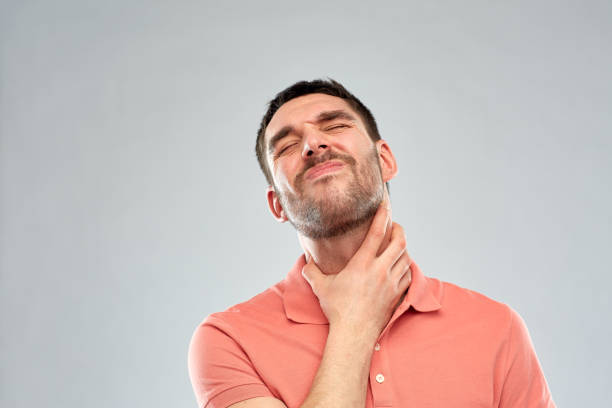 istock man touching neck and suffering from throat pain 1272761841