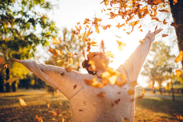 秋の公園で幸せな女性 - autumn women smiling leaf ストックフォトと画像