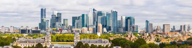 The crowded skyscraper cityscape of Docklands and Canary Wharf overlooking the River Thames at Greenwich, London, UK.