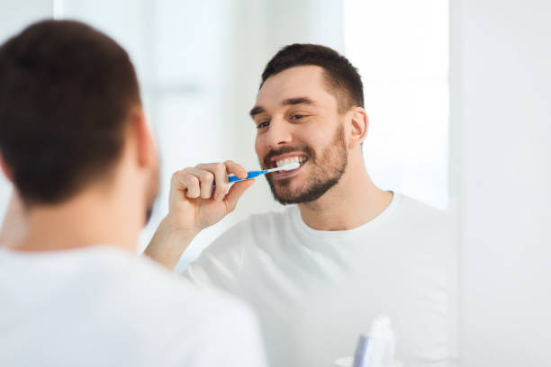 istock man with toothbrush cleaning teeth at bathroom 1272762282