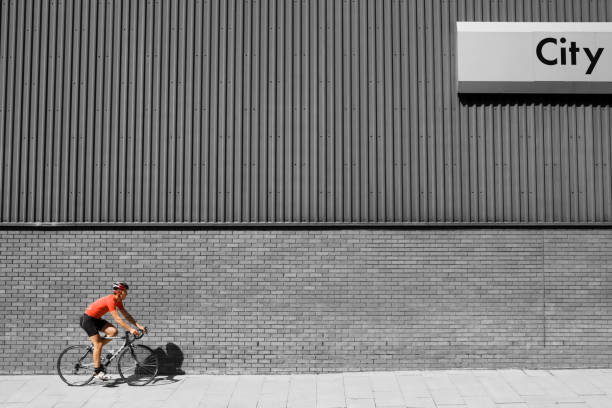 Man cycling past building with 'City' written on side