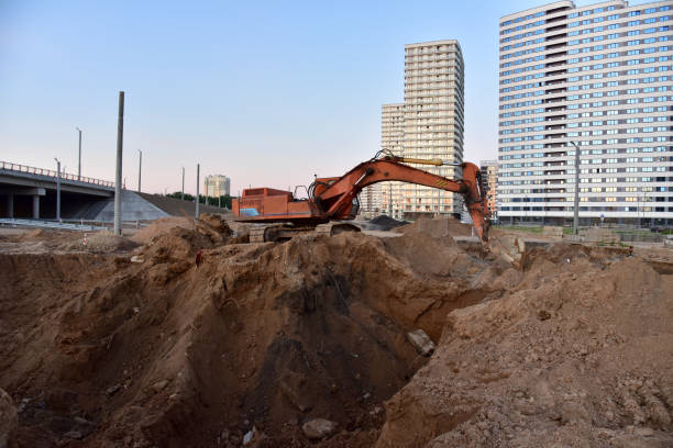 istock Excavator during excavation at construction site. Backhoe on road work 1272762517