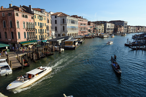 The famous Grand Canal (Canale Grande) in Venice with several boats and Gondolas seen at dusk. The image was made during the worldwide coronavirus epidemic in summer season.it