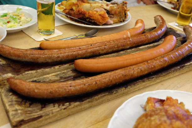 salsichas alemãs e dedos de porco fritos (pernas) servidos com cerveja, salada e molhos de mergulho - german culture salad prepared potato bratwurst - fotografias e filmes do acervo