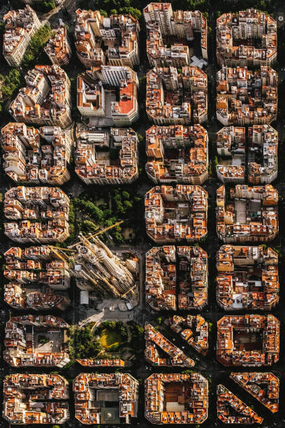вид с воздуха на жилой район эйксампл барселоны, с sagrada familia, спроектированный каталонским архитектором антони гауди - barcelona antonio gaudi outdoors vertical стоковые фото и изображения
