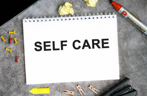 istock Self care text on a white notebook with pins, marker and stapler on a concrete table 1272765892