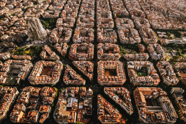 вид с воздуха на жилой район эйксампл барселоны, с sagrada familia, спроектированный каталонским архитектором антони гауди - barcelona стоковые фото и изображения