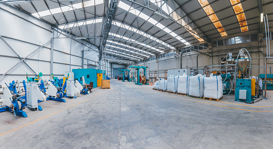 Heavy Machinery and steel cable processing equipments at the empty manufacturing plant in the factory warehouse.