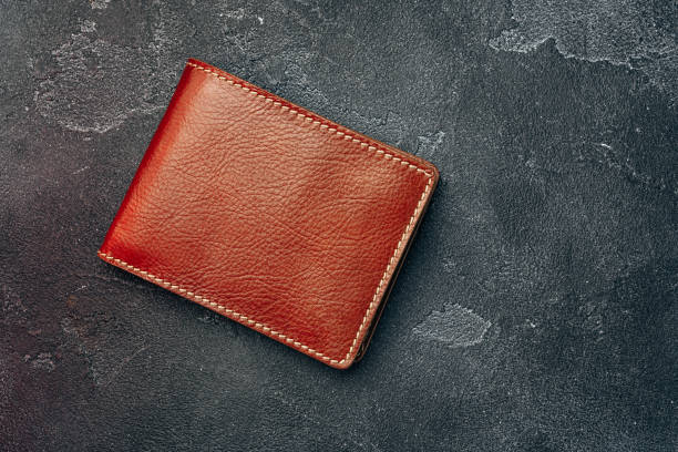 istock New brown leather wallet on dark background 1272769043