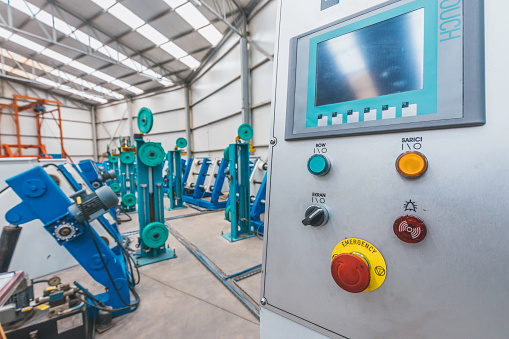 industrial control panel with colorful switch buttons for cable manufacturing machine in factory warehouse