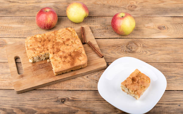 istock Piece of apple pie on a white plate and apple pie on a cutting board. 1272770380