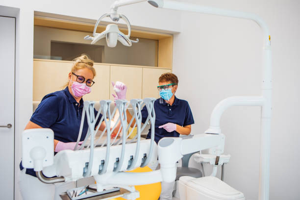 Two female dentist assistants in a dental surgery Two female dentist assistants consulting during their daily duties in a dental surgery dental drill stock pictures, royalty-free photos & images