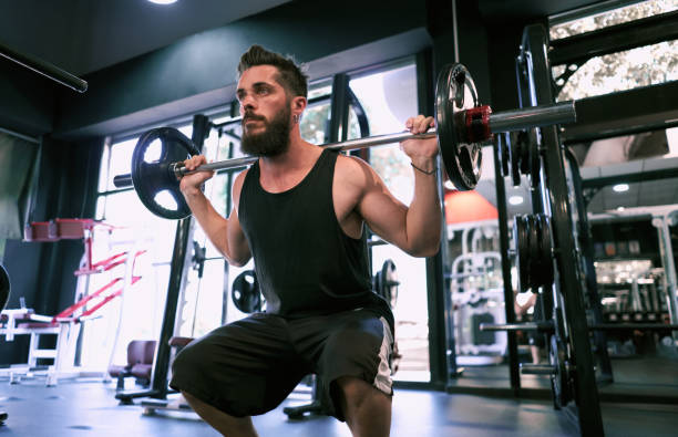istock One young man lifting weights at the gym. 1272773122