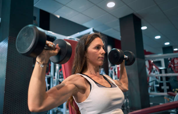 istock One young man lifting dumbbells at the gym. 1272773178