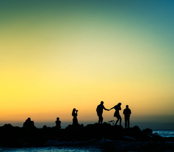 istock various people at sunset rocky shore 1272773967