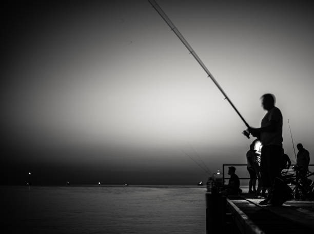istock a night fishermen, black and white 1272774613