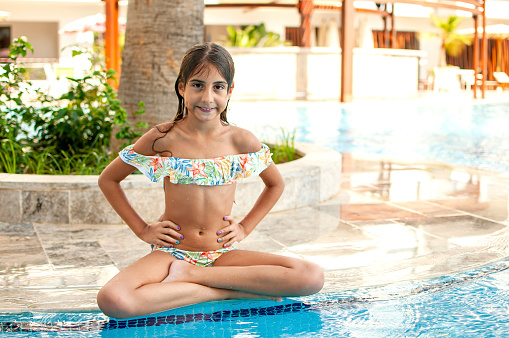 Happy little girl enjoying by the pool