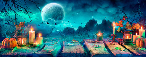 istock Spooky Halloween Table With Candles And Pumpkins At Night With Full Moon 1272775385