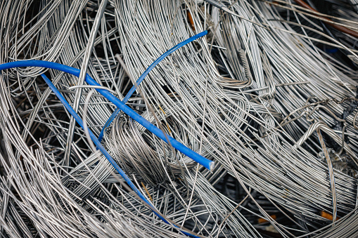 Pile of twisted old aluminum electrical cable recyclable scrap wires.