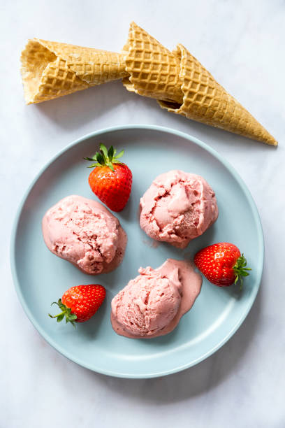 istock Blue ceramic plate with three scoops of strawberry ice cream 1272776160