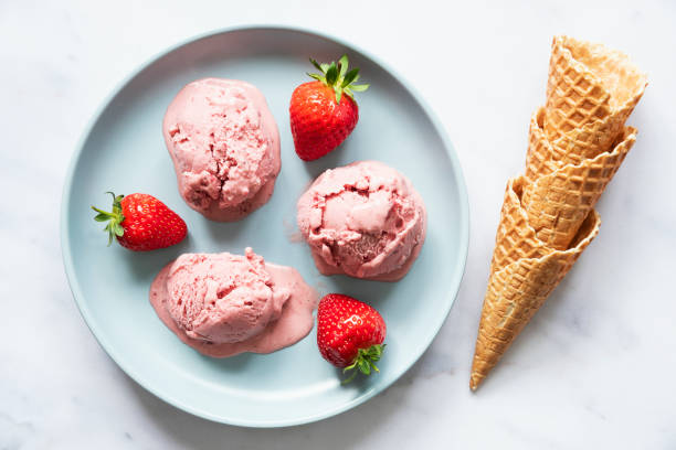 istock Blue ceramic plate with three scoops of strawberry ice cream 1272776203
